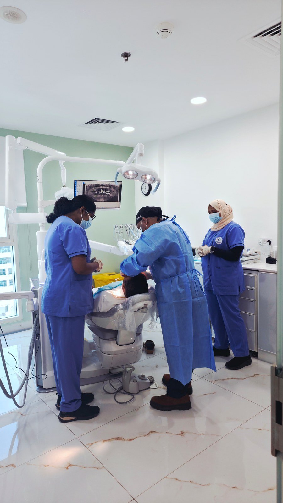Dental team working in a treatment room at Dr. Shouku Dental Clinic